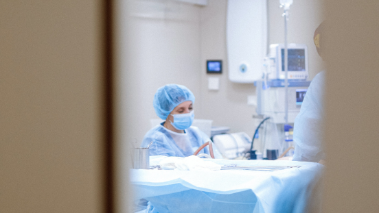 A healthcare worker with medical equipment nearby, shown between a doorway