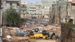 Damaged site from disaster, with a yellow car overturned